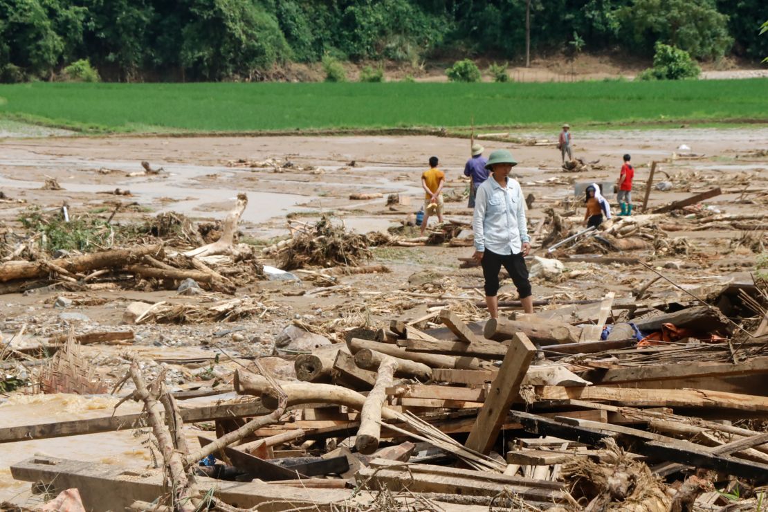 Residents clear debris in a village damaged by flash flooding in Vietnam's Yen Bai province on Saturday.