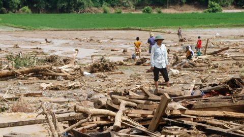 Residents clear debris in a village damaged by flash flooding in Vietnam's Yen Bai province on Saturday.