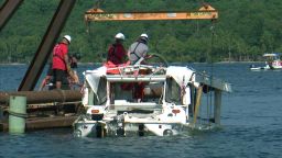 A duck boat that sank in Branson, Missouri, is raised out of the water. 