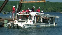 A duck boat that sank in Branson, Missouri, is raised out of the water. 