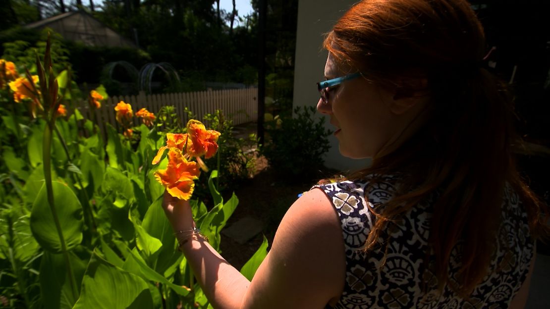 A horticultural therapy client pauses to admire a flower.