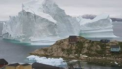 CAPTION CORRECTS PHOTOGRAPHER BYLINE In this Thursday, July 12, 2018 photo, a view of an Iceberg, near the village Innarsuit, on the northwestern Greenlandic coast. Scientists have watched an iceberg four miles long break off from a glacier. The iceberg is allegedly grounded on the sea floor. Residents in houses near the shore are prepared for an evacuation. (Magnus Kristensen/Ritzau Scanpix via AP)