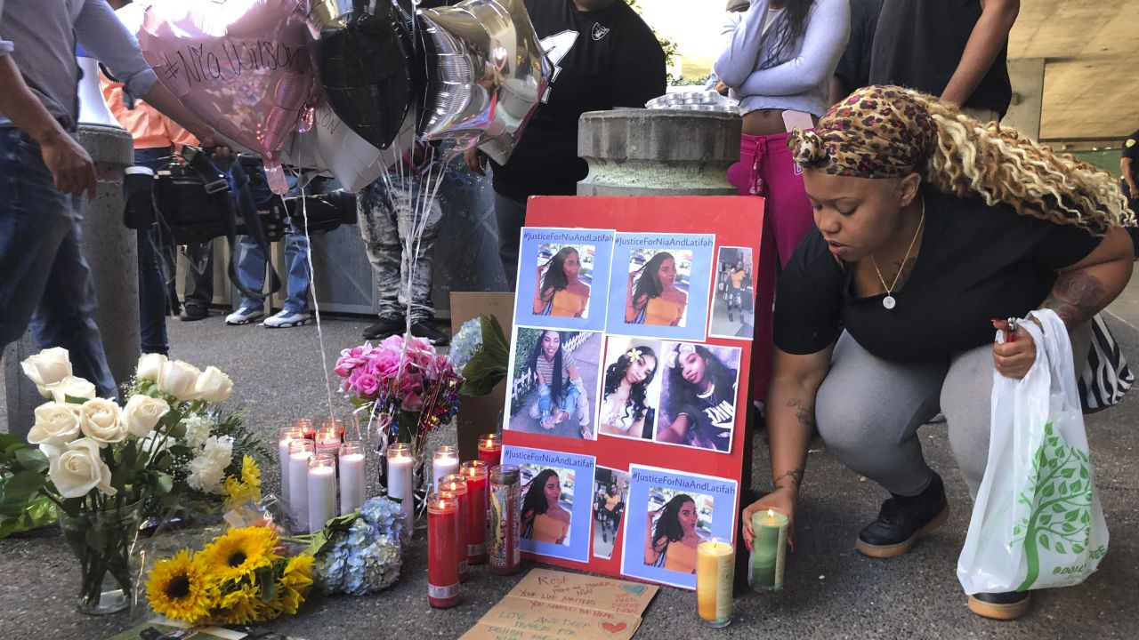 Malika Harris places a candle down for her sister Nia Wilson at a makeshift memorial outside the MacArthur Bay Area Rapid Transit station, Monday, July 23, 2018, in Oakland. 