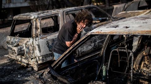 A woman searches her dog following a wildfire at the village of Mati, near Athens.