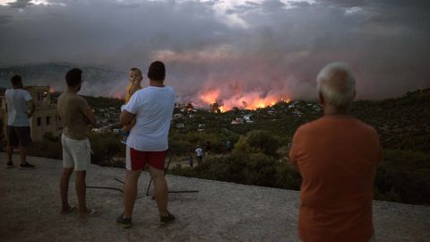 People watch a wildfire in Rafina on Monday.