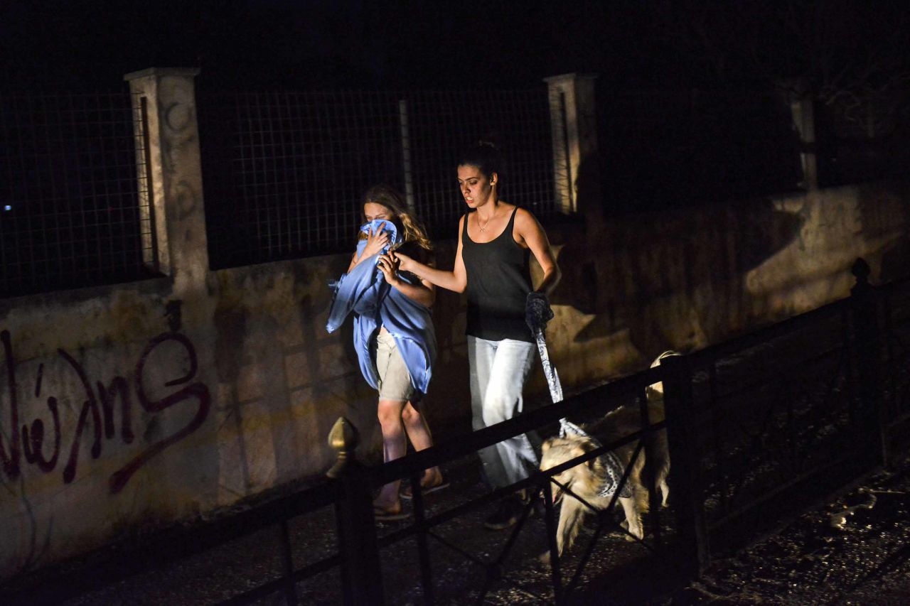 Two women evacuate Mati on July 23.