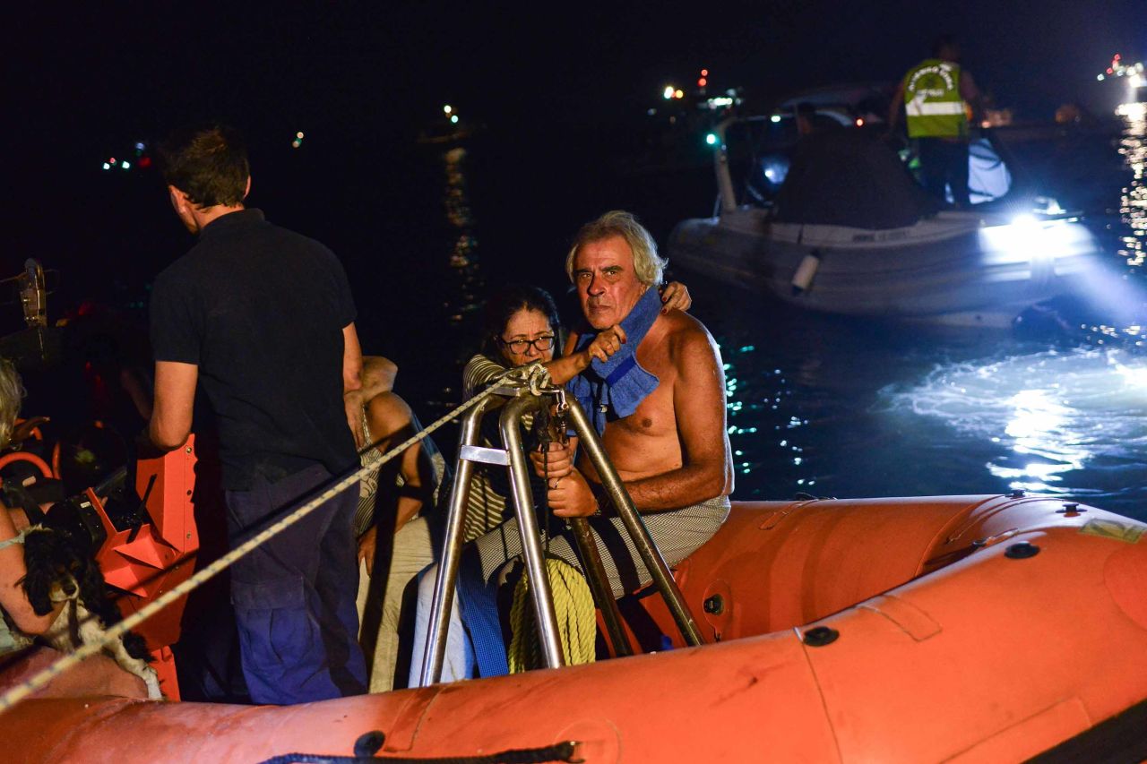 Rescuers and volunteers help residents evacuate Mati on July 23.