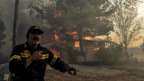 A firefighter works to quell the blaze in Kineta, west of Athens Monday.