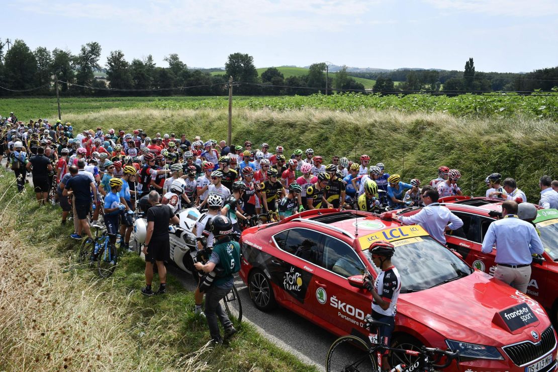The pack of riders waits for the stage to resume.