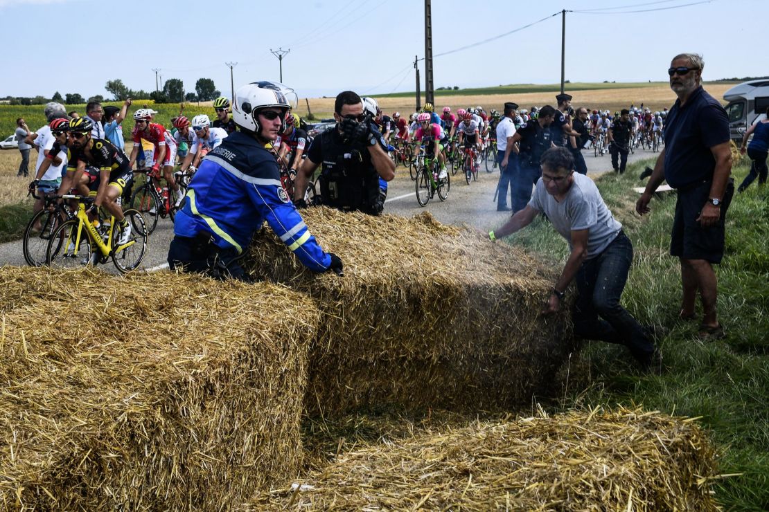 Gendarmes remove haystacks that were placed on the stage's route.