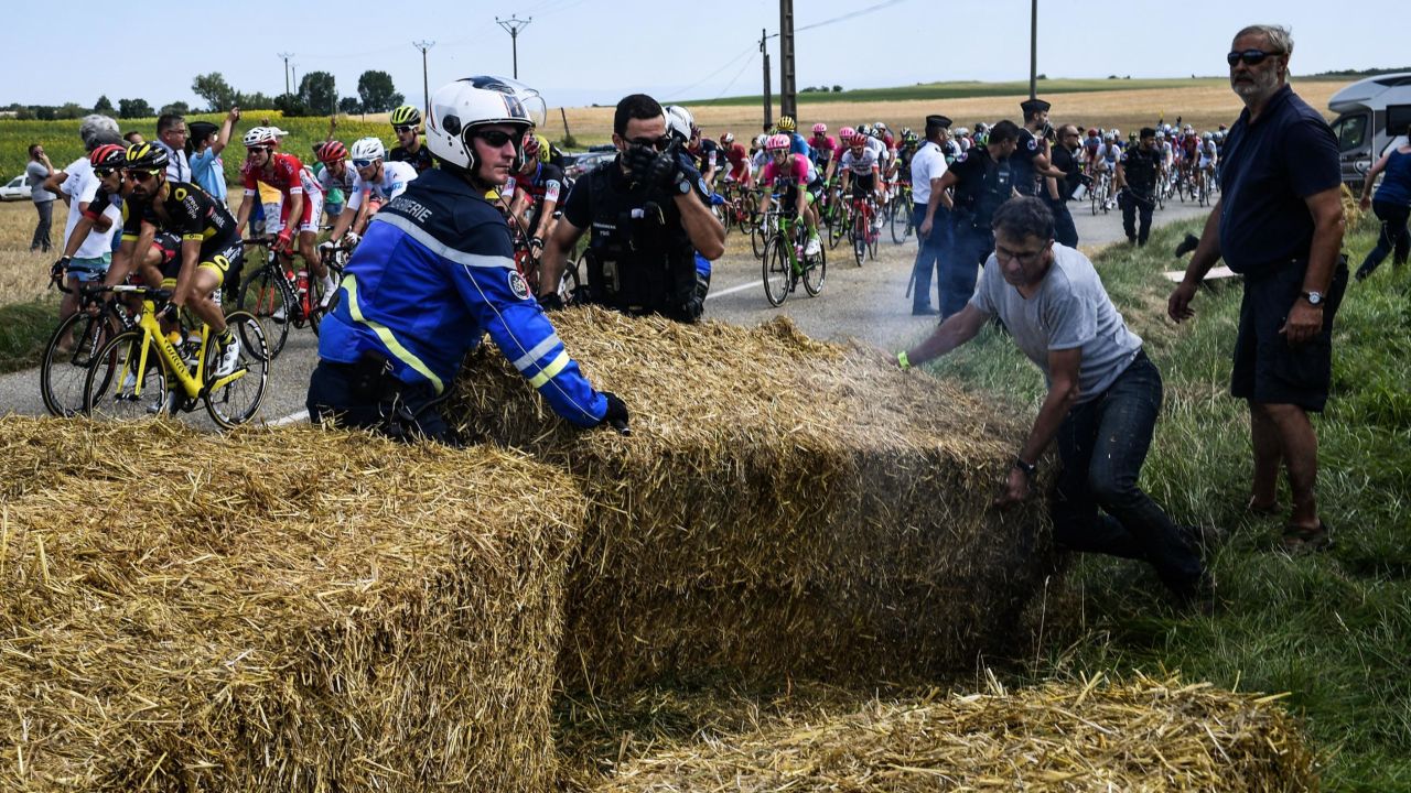 Gendarmes remove haystacks that were placed on the stage's route.