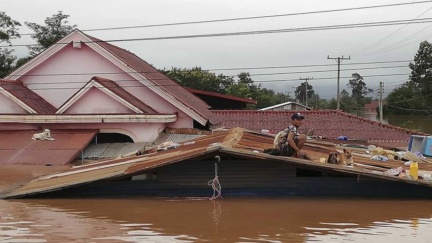 A villager takes refuge on a rooftop above flood waters from a collapsed dam in the Attapeu district of southeastern Laos, Tuesday, July 24, 2018. The official Lao news agency KPL reported Tuesday that the Xepian-Xe Nam Noy hydropower dam in Attapeu province collapsed Monday evening, releasing large amounts of water that swept away houses and made more than 6,600 people homeless. (Attapeu Today via AP)