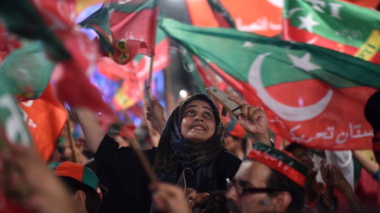 Supporters of Pakistani cricket star-turned-politician and head of the Pakistan Tehreek-e-Insaf (PTI) Imran Khan, cheer and wave flags during a rally during the last campaign day, in Lahore, on July 23, 2018.