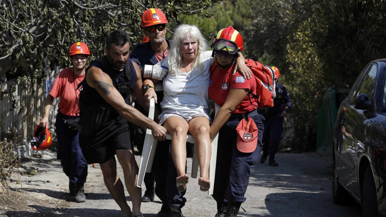 Members of a rescue team carry an injured woman Wednesday in Mati.