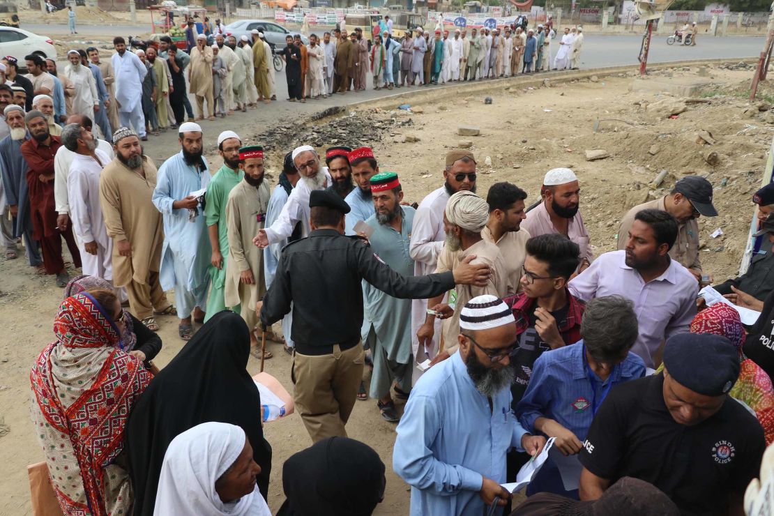 Voters wait in line Wednesday to cast their ballots at a polling station in Karachi.  