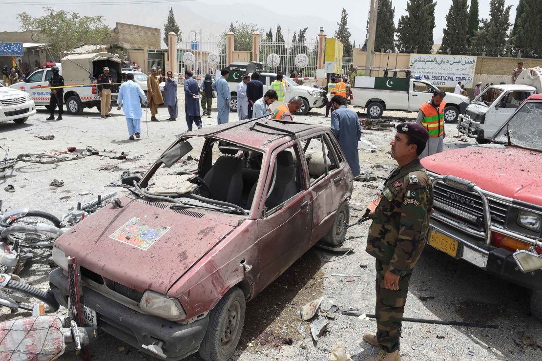 Pakistani volunteers and security officers visit the site of the bombing Wednesday in Quetta.