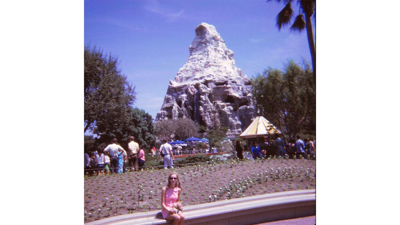 Judy sitting in front of the Matterhorn Bobsleds ride, which still operates.