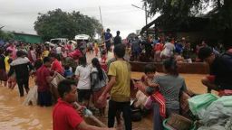 In this Tuesday, July 24, 2018, photo, people are evacuated through the floodwaters from a collapsed dam in southeastern Laos. Rescue efforts are ongoing in villages flooded after part of a newly built hydroelectric dam was breached in southeastern Laos. (Attapeu TV via AP)