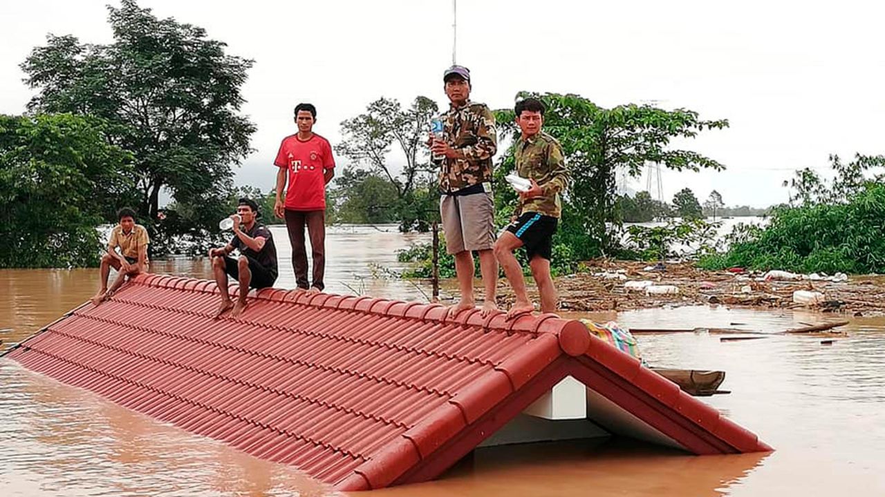 Villagers take refuge from the flood waters on a rooftop in the Attapeu province of Laos on Tuesday, July 24, 2018.  