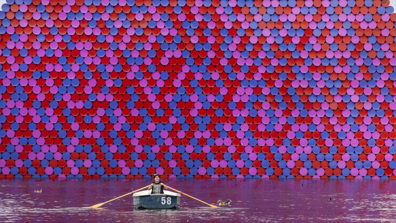 <strong>London, UK: </strong>As a heatwave hits the UK capital, a woman rows past the London Mastaba, a floating sculpture created by Romanian artist Christo in the Serpentine lake in Hyde Park.