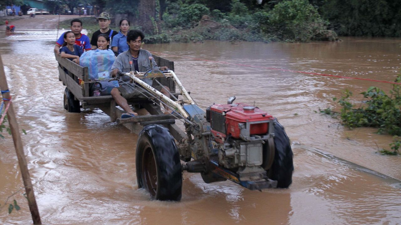 Residents cross flooded areas of Sanamxai, Attapeu province on Wednesday.