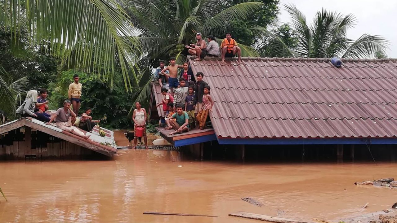 People are stranded on  rooftops Tuesday after a dam under construction collapsed in Laos.