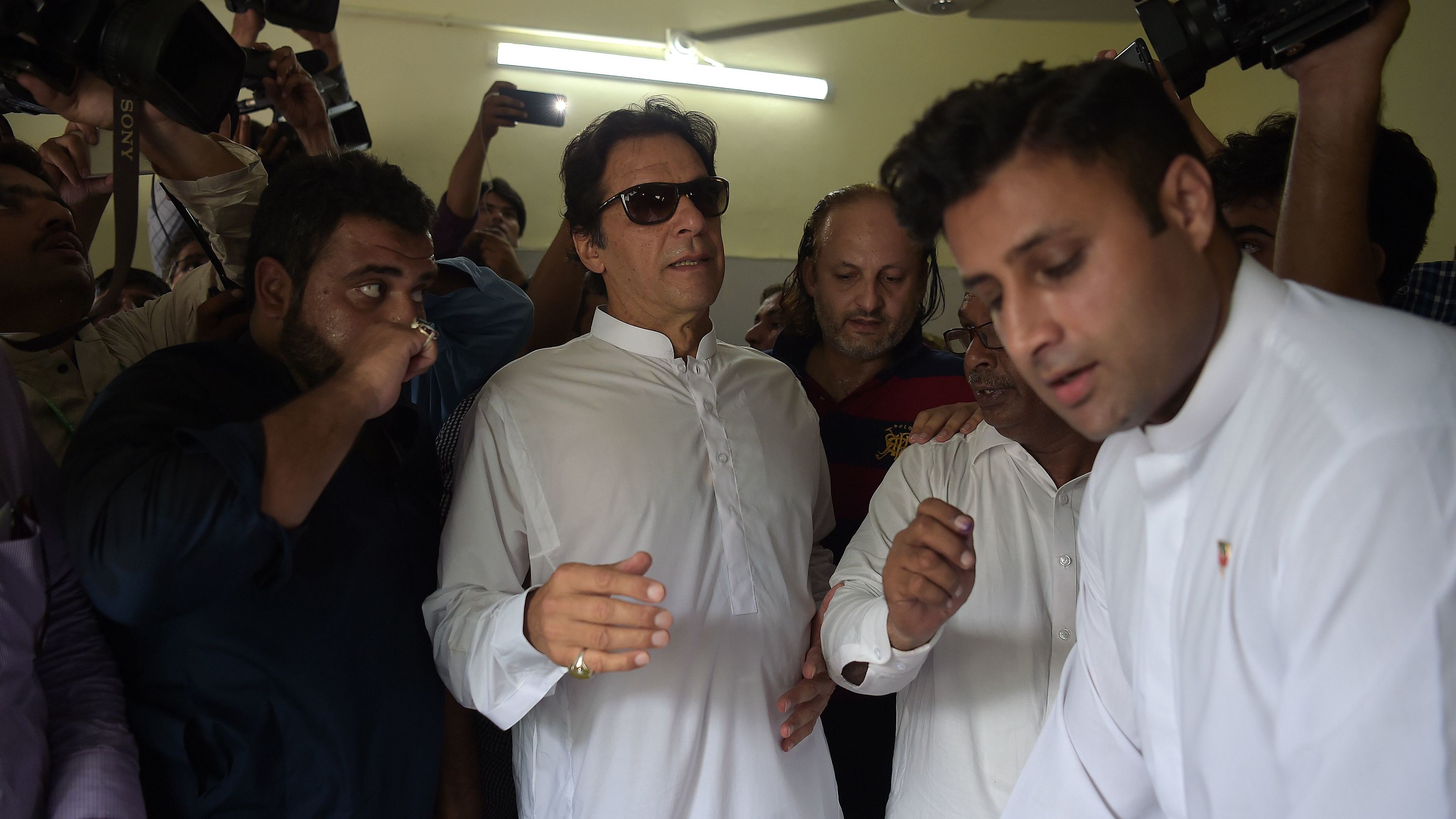 Cricket star-turned-politician Imran Khan arrives at an Islamabad polling station to vote Wednesday.