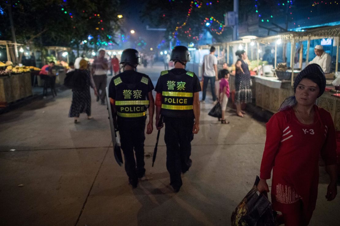 This picture taken on June 25, 2017 shows police patrolling in a night food market near the Id Kah Mosque in Kashgar in China's Xinjiang Uighur Autonomous Region, a day before the Eid al-Fitr holiday.