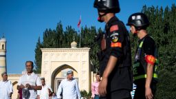 (FILES)This file picture taken on June 26, 2017 shows police patrolling as Muslims leave the Id Kah Mosque after the morning prayer on Eid al-Fitr in the old town of Kashgar in China's Xinjiang Uighur Autonomous Region. - All Chinese mosques should raise the national flag to "promote a patriotic spirit" among Muslims, the country's top Islamic regulatory body has declared, as the ruling Communist Party seeks to further extend its control over religion. (Photo by JOHANNES EISELE / AFP)        (Photo credit should read JOHANNES EISELE/AFP/Getty Images)