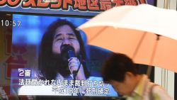 A pedestrian walks past a screen flashing news on the execution of Shoko Asahara, the leader of the Aum Shinrikyo cult, in Tokyo on July 6, 2018. - Shoko Asahara, the leader of the Aum Shinrikyo cult that carried out a deadly sarin attack on Tokyo's subway in 1995, was executed on July 6, two decades after the group's shocking crime. (Photo by Toshifumi KITAMURA / AFP)        (Photo credit should read TOSHIFUMI KITAMURA/AFP/Getty Images)