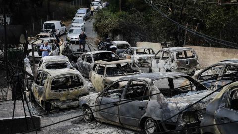 Burnt cars are seen in Mati following the wildfire.