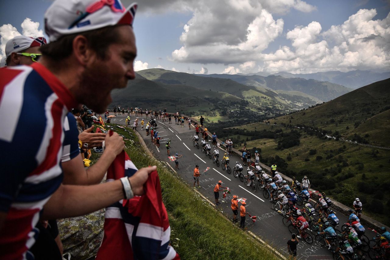 Spectators cheer as a pack of cyclists rides uphill during the 17th stage of the Tour de France on Wednesday, July 25.