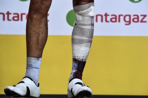 Belgium's Philippe Gilbert stands on the podium after the 16th stage on Tuesday, July 24. He injured his leg in a crash and had to bow out of the Tour.