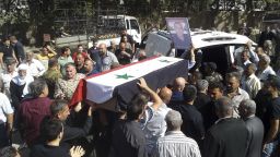 In this photo released by the Syrian official news agency SANA, mourners carry a coffin of more than 200 people who were killed a day earlier by a series of suicide bombings launched by the Islamic State's fighters on the eastern and northern countryside of the southern province of al-Sweida during a mass funerals in al-Sweida, Syria, Thursday, July 26, 2018. A Syrian government official says the death toll from coordinated Islamic State attacks on a usually peaceful city and its countryside has climbed to 216, in the worst violence to hit the area since the country's conflict began. (SANA via AP)