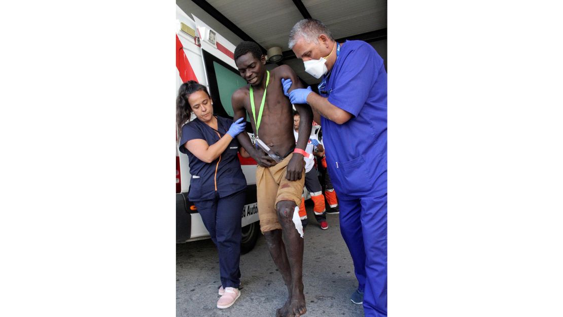 A sub-Saharan African migrant is assisted by Spanish paramedics in Ceuta.
