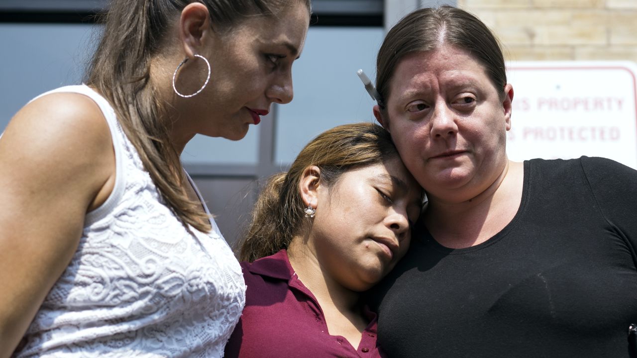 Yeni Gonzalez, a Guatemalan mother who was separated from her three children at the US-Mexico border, center, is embraced by volunteers after being driven cross-country to see her children for the first time in weeks. 