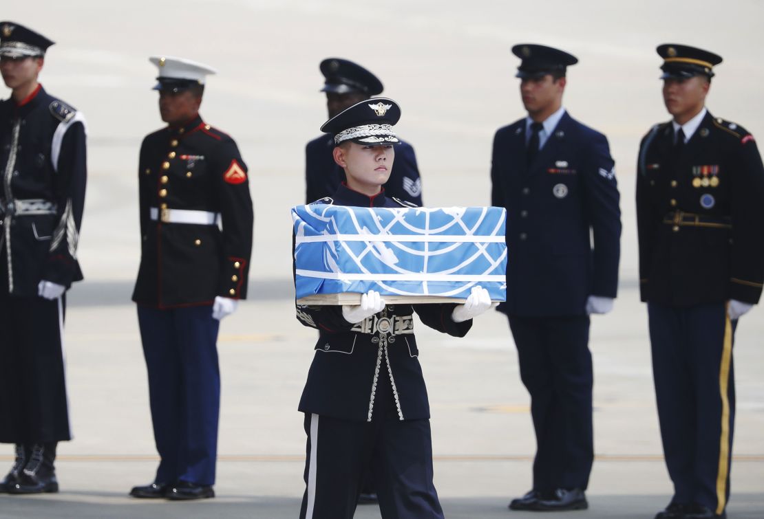 A service member at Osan Air Base in Pyeongtaek, South Korea, carries a casket containing what is believed to be the remains of a US soldier killed during the Korean War, after it was transported from North Korea. 
