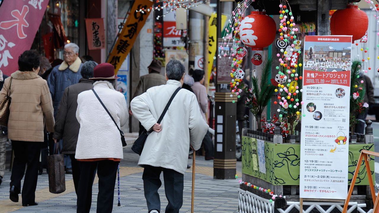 Elderly people walk in the street at Kouganji Temple in Tokyo.