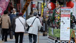 Elderly people walk in the street at Kouganji Temple in Tokyo.