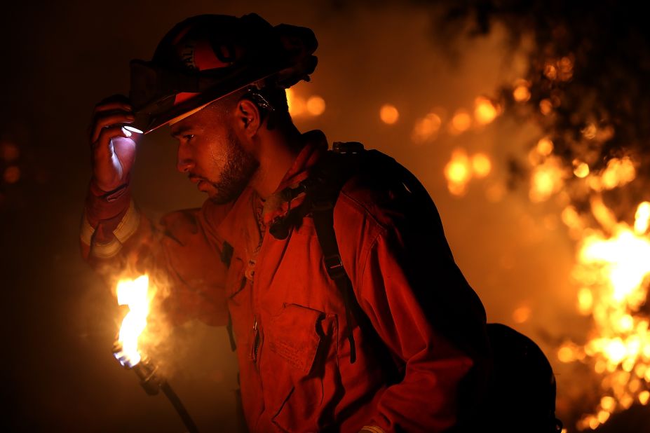 A firefighter monitors a backfire while battling the Carr Fire on July 27. The fire grew rapidly, ravaging several small communities and jumping the Sacramento River before threatening the outskirts of Redding.