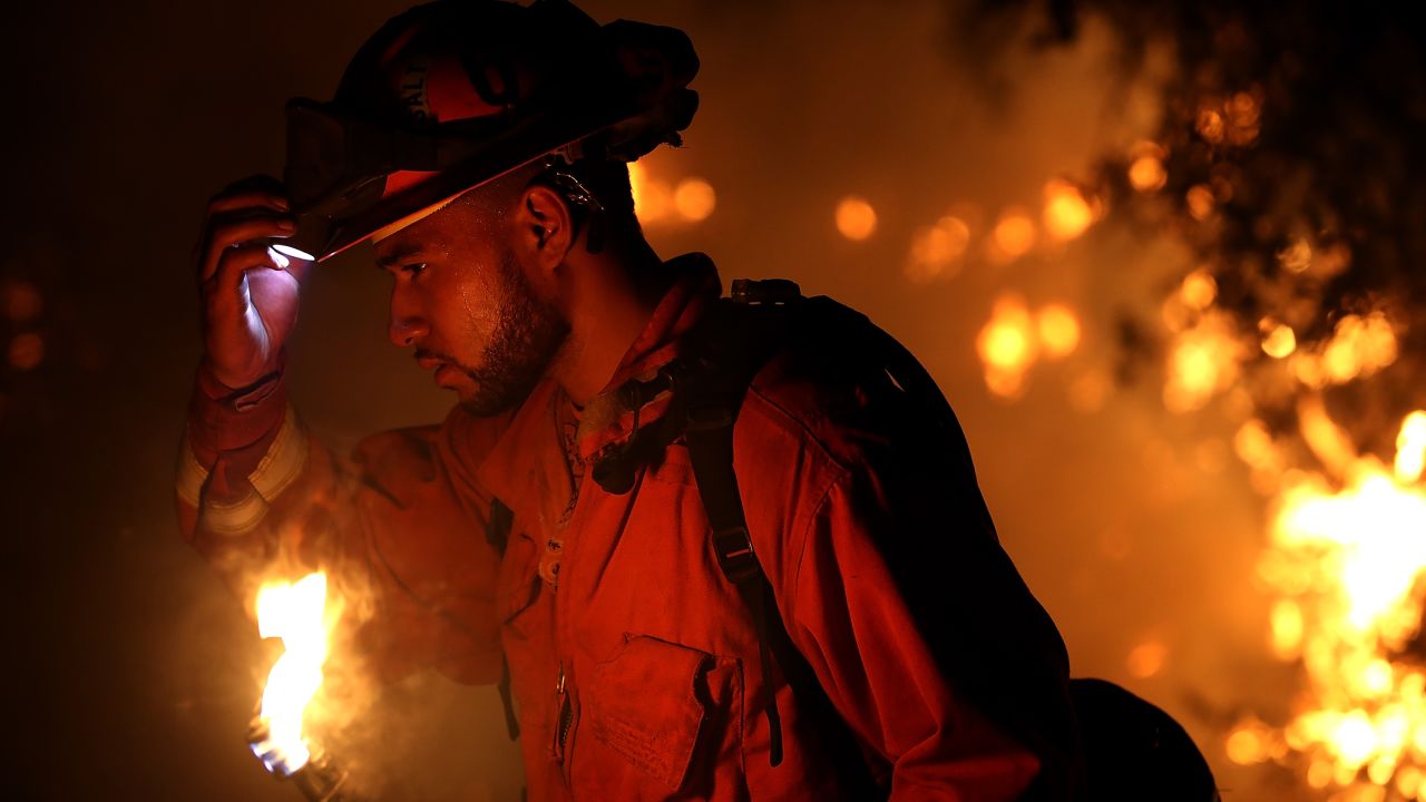 A firefighter monitors a backfire while battling the larger Carr Fire on Friday in Redding.