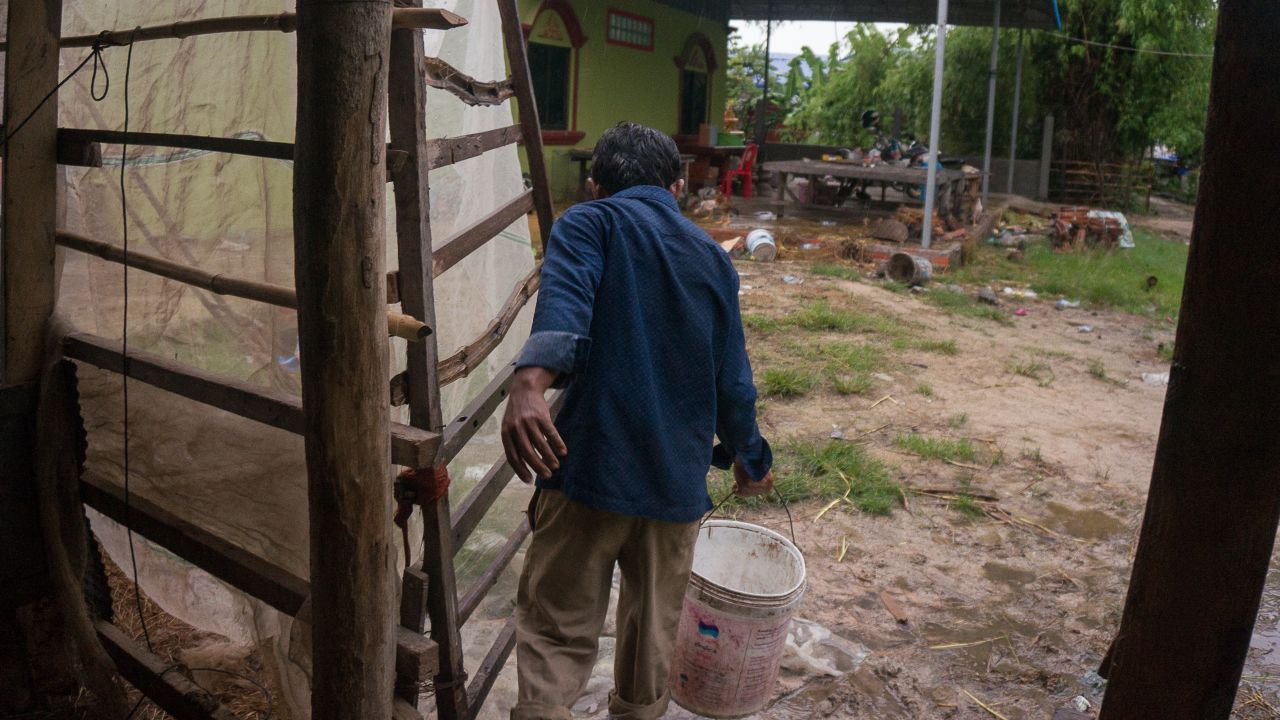 Bo walking out a cow shed. "If we have trouble and go to see the official in the government, they won't care about you if they think you support another party," he says.