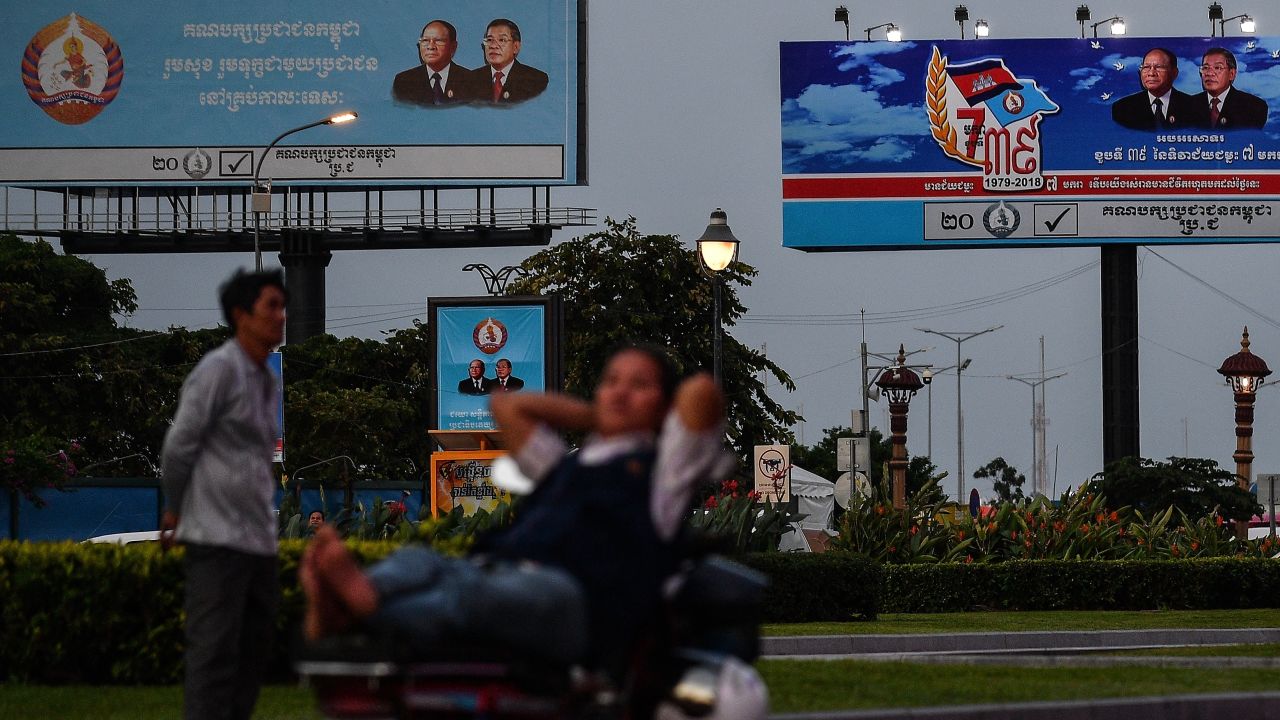 A Cambodian man rests on a bike near electoral hoardings of Cambodia's Prime Minister and leader of the ruling Cambodian People's Party (CPP) Hun Sen, in Phnom Penh on July 26, 2018.