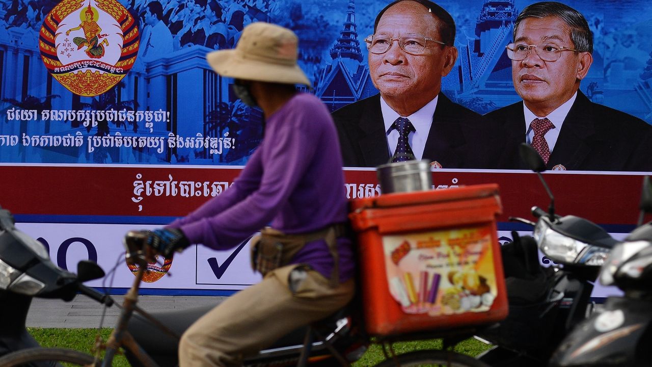 A cyclist rides past an electoral hoarding of Cambodia's Prime Minister and leader of the ruling Cambodian People's Party (CPP) Hun Sen, in Phnom Penh on July 26, 2018. 