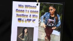 Images of Nia Wilson, who was fatally stabbed at a BART Station, are worn by a family member Wednesday, July 25, 2018, outside a courtroom in Oakland, Calif. A paroled robber who allegedly stabbed a woman to death and wounded her sister in an unprovoked attack at a California train station was charged with murder and attempted murder on Wednesday. John Cowell, 27, was set to be arraigned in Oakland in the attack against Nia Wilson, 18, of Oakland, and her 26-year-old sister, Letifah Wilson. (AP Photo/Ben Margot)