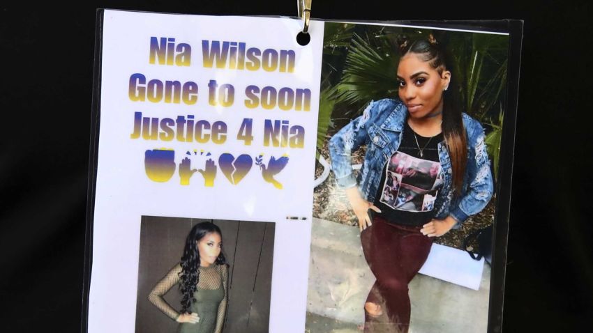 Images of Nia Wilson, who was fatally stabbed at a BART Station, are worn by a family member Wednesday, July 25, 2018, outside a courtroom in Oakland, Calif. A paroled robber who allegedly stabbed a woman to death and wounded her sister in an unprovoked attack at a California train station was charged with murder and attempted murder on Wednesday. John Cowell, 27, was set to be arraigned in Oakland in the attack against Nia Wilson, 18, of Oakland, and her 26-year-old sister, Letifah Wilson. (AP Photo/Ben Margot)
