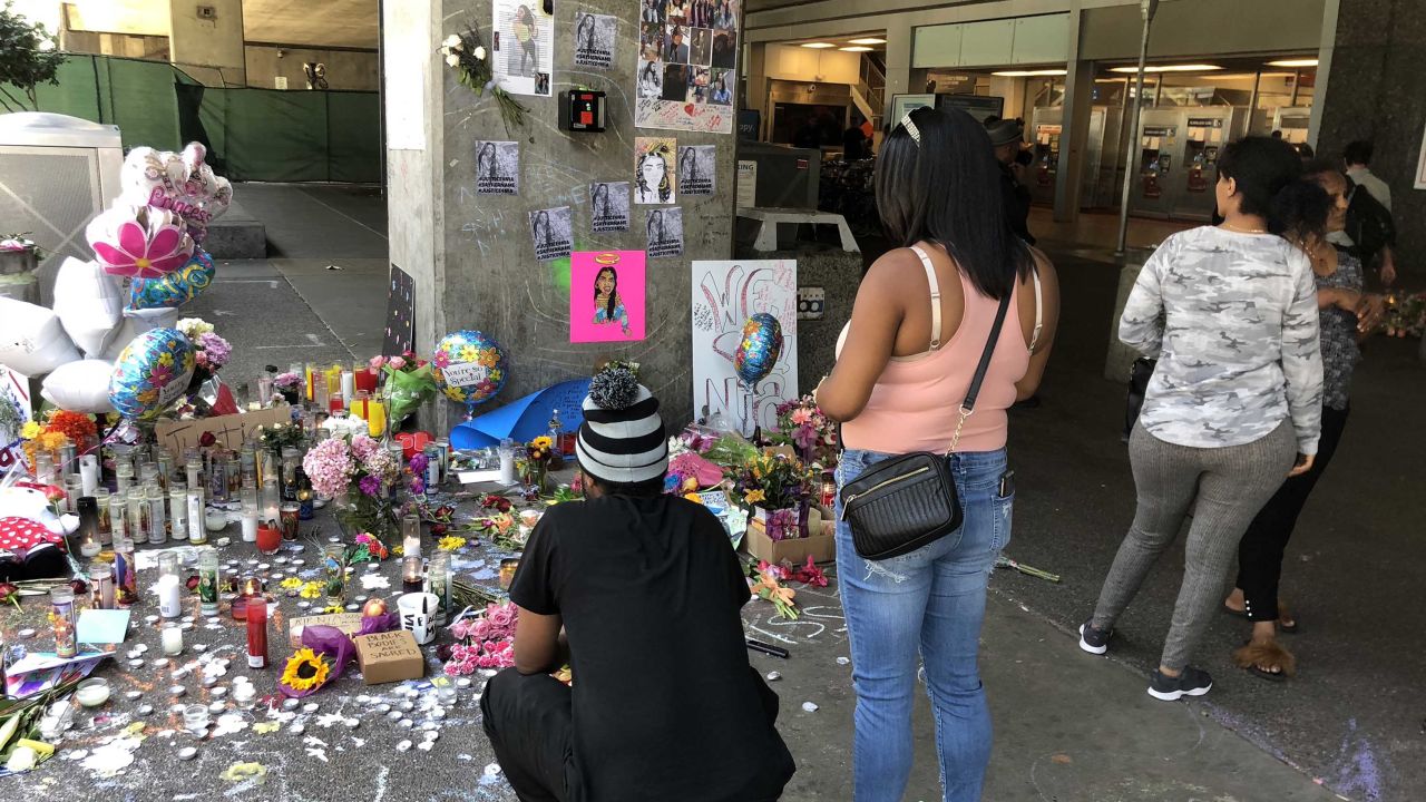 Oakland residents  visit a memorial to Nia Wilson at the BART station where she was killed.