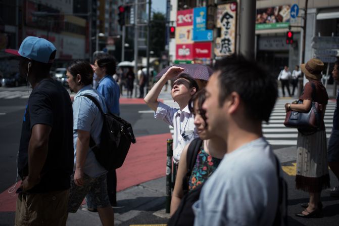 A man in Tokyo shields his eyes from the sun on Tuesday, July 24. Dozens of people have died across Japan as the country continues to swelter under <a href="index.php?page=&url=https%3A%2F%2Fwww.cnn.com%2F2018%2F07%2F23%2Fasia%2Fjapan-heatwave-deadly-intl%2Findex.html" target="_blank">scorching summer temperatures.</a>