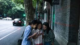 Women look at their smartphones in Xintiandi district, a shopping area, in Shanghai on September 8, 2016. / AFP / FRED DUFOUR        (Photo credit should read FRED DUFOUR/AFP/Getty Images)