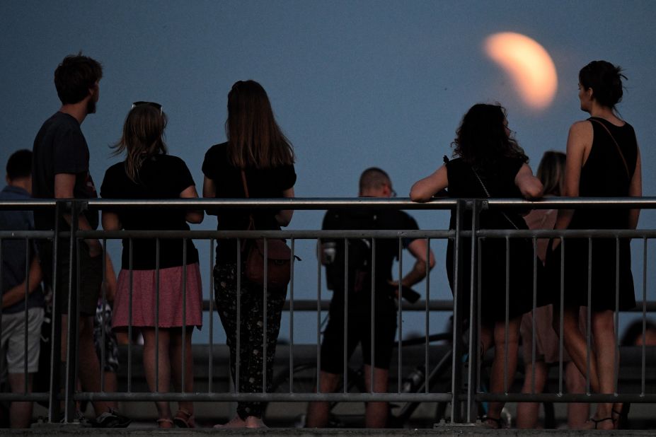 People watch an early phase of the eclipse from Warsaw, Poland.